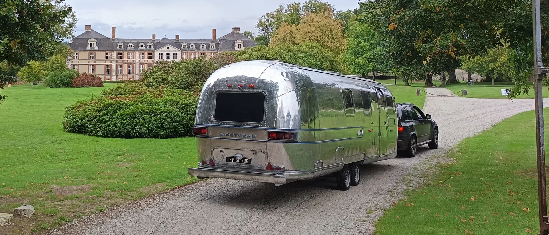 Scène mobile Airstream Sovereign 1975 en déplacement devant un château en Normandie